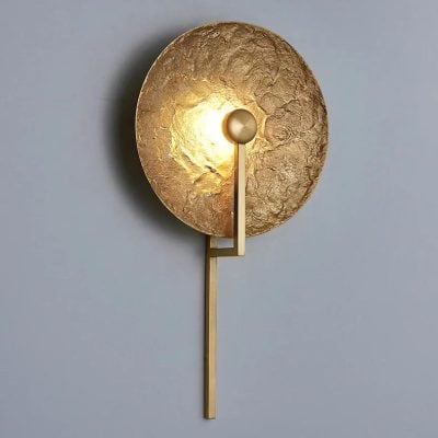 Gold textured wall sconce with modern lighting design for luxury interior decor.