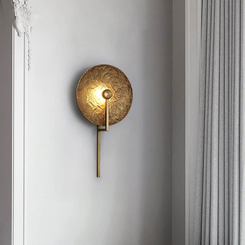 Shiny gold wall sconce with textured round backdrop and minimalist design, perfect for modern interior lighting in opt clinics and medical spaces.
