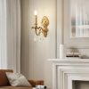 Elegant gold wall sconce with crystal embellishments illuminating a sophisticated living room decor.