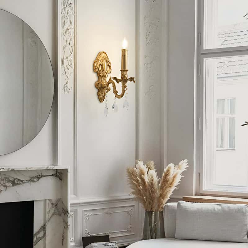 Elegant interior with ornate wall sconce, decorative mirror, marble fireplace, and cozy seating area featuring pampas grass decor, highlighting sophisticated home aesthetic and luxurious design.