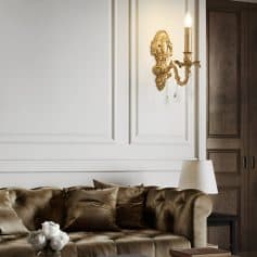 Luxury interior design with elegant sofa and classic wall sconce lighting in sophisticated living room setting.