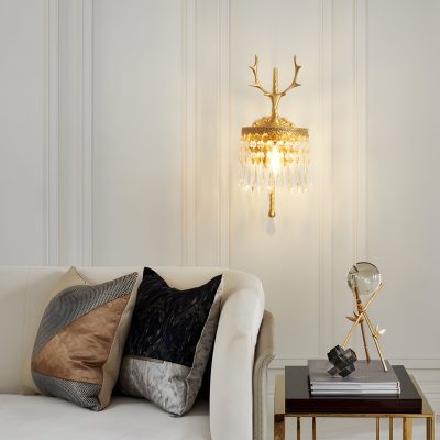 Elegant interior design with a decorative golden wall sconce featuring crystal accents and a cream-colored sofa adorned with stylish throw pillows, creating a luxurious living space for optometry and eyewear clinics.