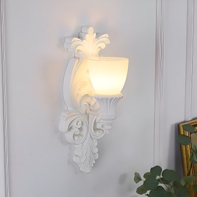 Elegant white ornamental wall sconce with classic design, perfect for enhancing interior decor at Monalisa Opt Med Spa. Stylish lighting fixture adds luxury and sophistication to your space.