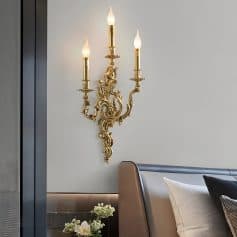 Elegant gold wall-mounted chandelier with candle-style lights, adding luxury and ambiance to modern bedroom decor. Perfect for upscale interior design and sophisticated lighting solutions.