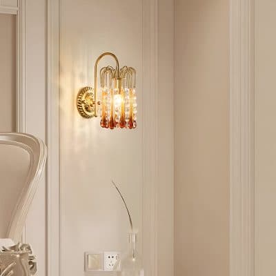 Elegant gold and crystal wall sconce lighting fixture with warm ambient light, perfect for luxurious interior design in optometry clinics or upscale optical stores.
