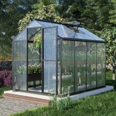 Modern glass greenhouse for gardening and plant care, featuring durable aluminum frame and transparent panels for optimal sunlight, ideal for outdoor plant cultivation.