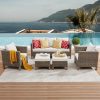 Stylish outdoor lounge with wicker furniture, cozy cushions, and a view of the ocean and mountains, perfect for relaxing on the Monalisa Store patio.