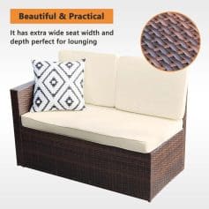Wicker garden sofa with cream cushions and decorative black and white pillow, featuring wide seat and backrest for relaxing comfort.