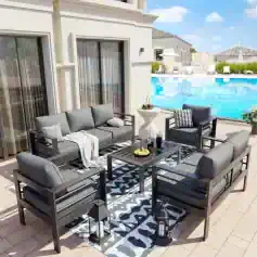 Modern outdoor patio furniture set with gray cushioned sofas and armchairs on a poolside terrace at Monalisa Store.