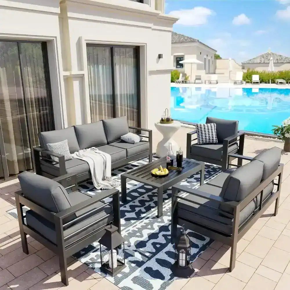 Modern outdoor patio furniture set with gray cushioned sofas and armchairs on a poolside terrace at Monalisa Store.