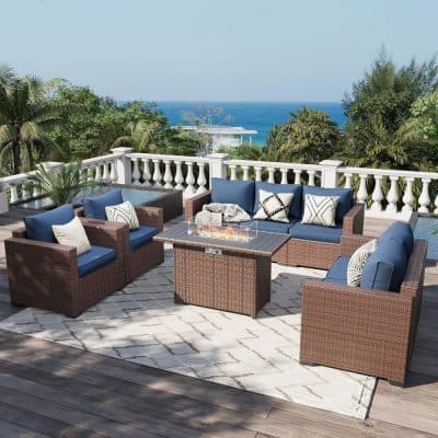 Elegant outdoor patio furniture set with wicker sofas and armchairs featuring blue cushions, perfect for relaxation and social gatherings with a scenic ocean view.