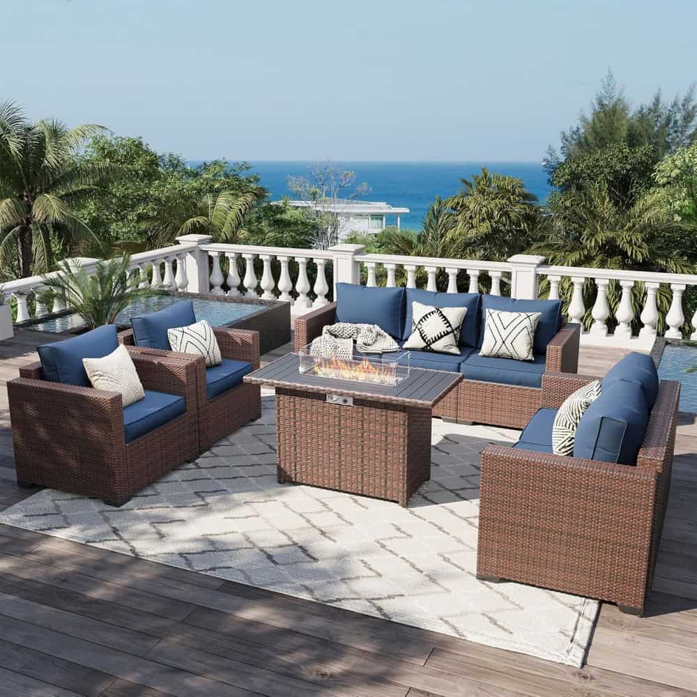 Elegant outdoor patio furniture set with wicker sofas and armchairs featuring blue cushions, perfect for relaxation and social gatherings with a scenic ocean view.