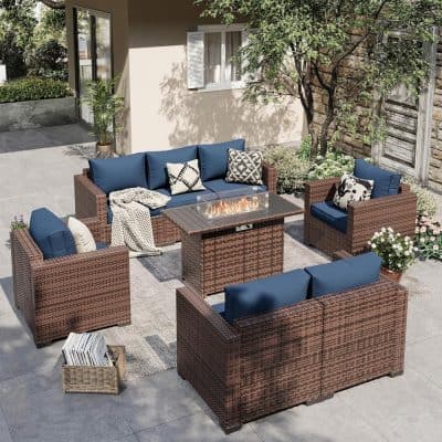 Outdoor wicker patio furniture with blue cushions and a modern fire pit in a stylish backyard setting.