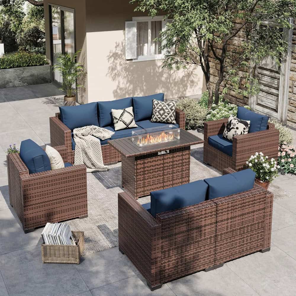 Outdoor wicker patio furniture with blue cushions and a modern fire pit in a stylish backyard setting.