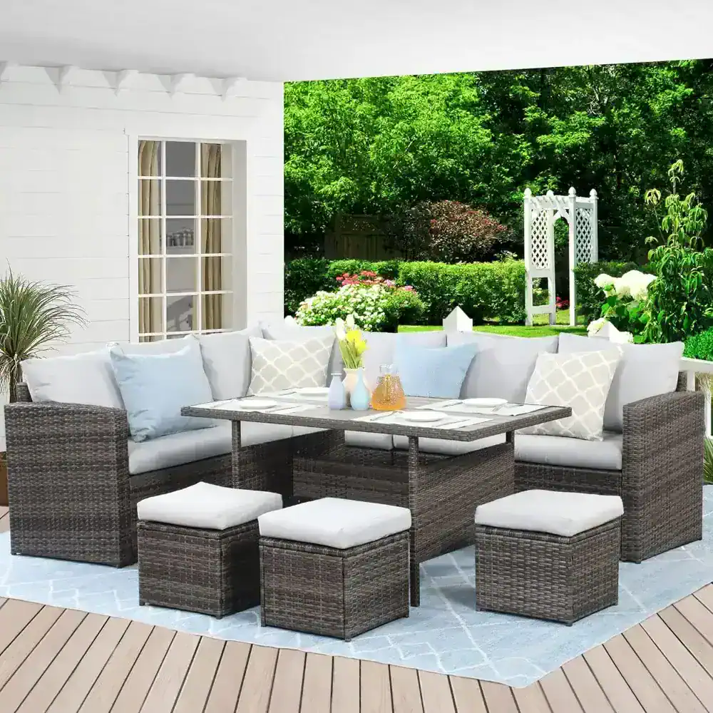 Stylish outdoor patio furniture set with wicker sectional sofa, ottomans, and a dining table, perfect for garden relaxation and entertaining in a lush backyard.