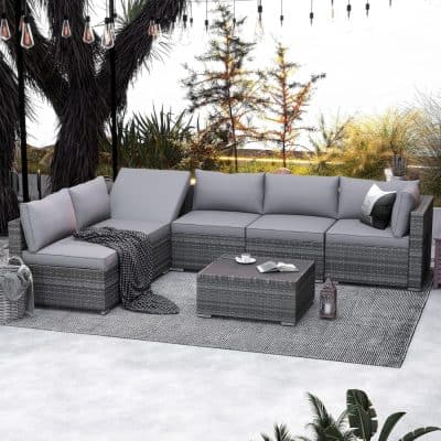 Modern outdoor sectional sofa with gray cushions and woven rattan frame on patio with natural greenery, perfect for stylish outdoor living and entertaining.