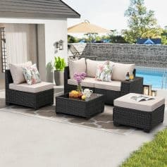Luxurious outdoor patio furniture set with cushioned wicker sofas, coffee table, and armchair, perfect for relaxing by the pool, featuring floral pillows and garden decor at Monalisa Store.
