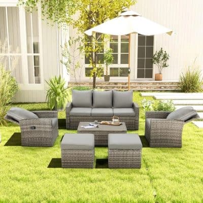 Stylish outdoor patio furniture set with wicker sofas, armchairs, and ottomans beneath a large patio umbrella, ideal for garden or backyard relaxation and entertaining.