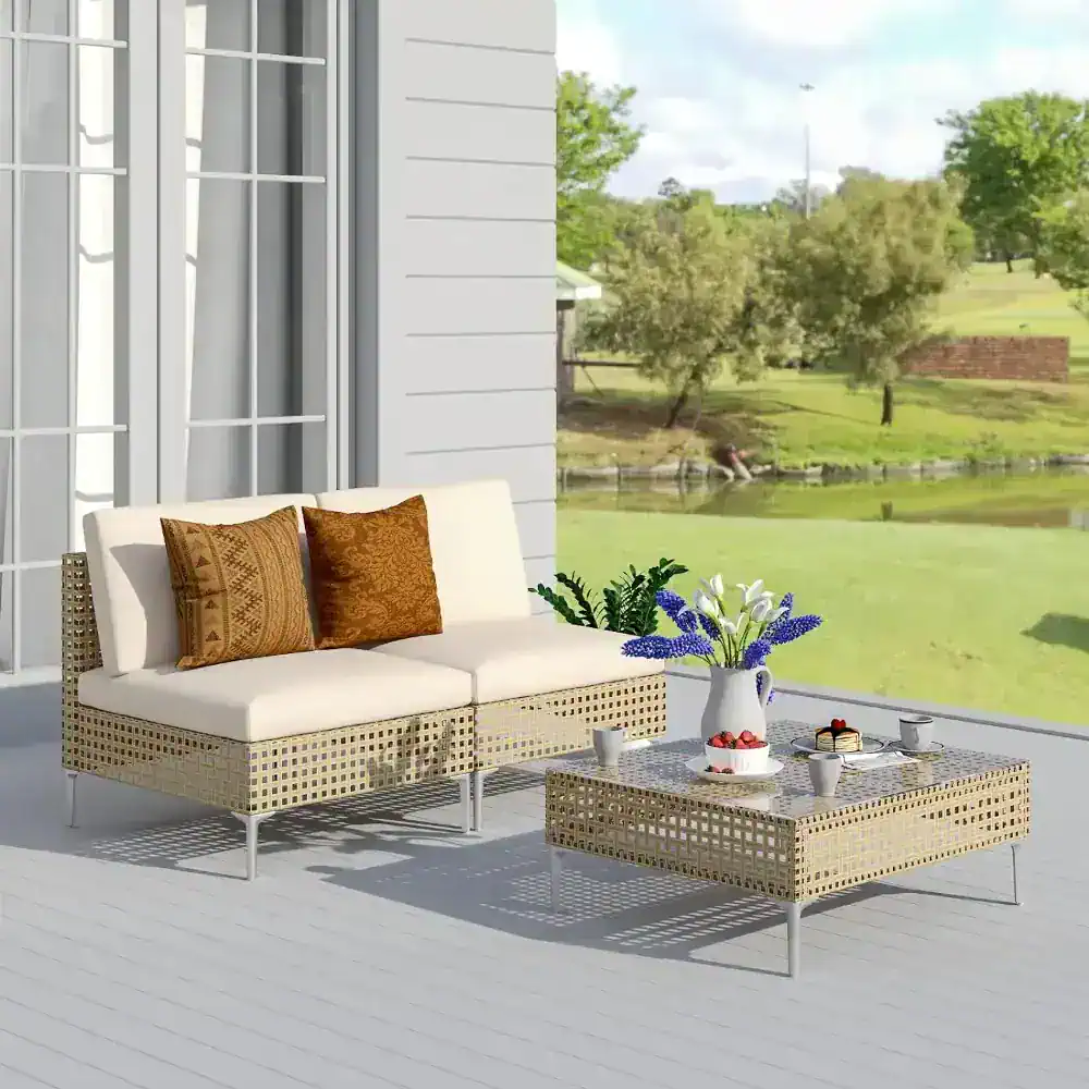 Elegant outdoor patio furniture with neutral cushions and decorative pillows, set in a peaceful garden view; perfect for relaxing and entertaining.