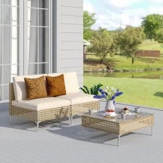 Stylish outdoor seating area with wicker sofa and coffee table, perfect for garden relaxation and outdoor living. Featuring comfortable cushions and fresh flowers for a cozy, inviting atmosphere.