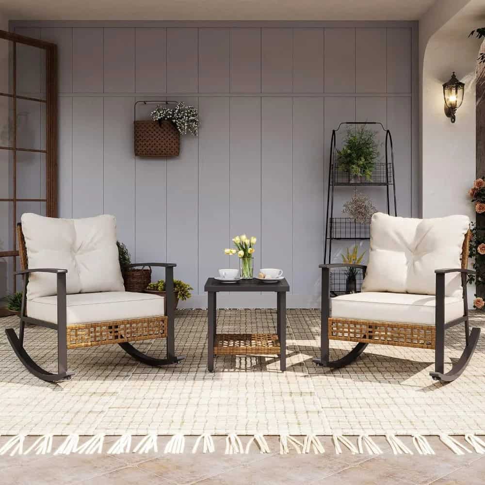Stylish outdoor seating area with rocking chairs, cozy cushions, and a coffee table, perfect for relaxing and enjoying spring or summer days in a home or garden setting.