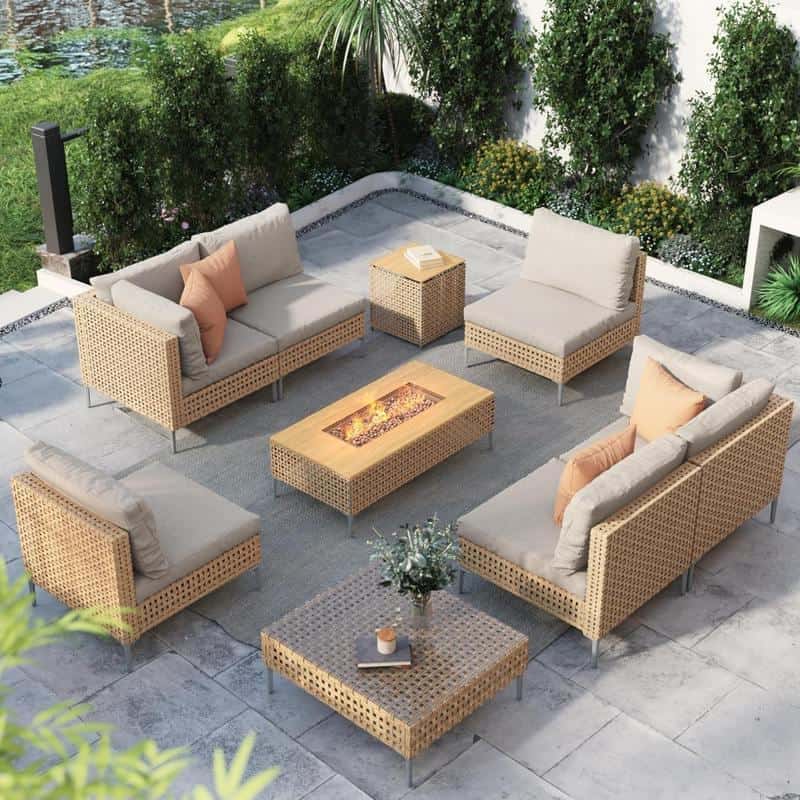 Lounge outdoor seating set with woven rattan furniture, neutral cushions, and a fire pit table on a stylish patio surrounded by lush greenery for relaxing outdoor living.