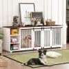 Cozy pet play area with black and white dog inside a white wooden dog crate with black metal bars, set against a decorative shelf with artwork, books, and a flower vase in a stylish living room.