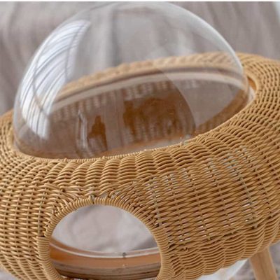Acrylic double-layered space capsule-shaped pet house with rattan base and transparent dome, ideal for cozy and stylish pet accommodations. Featuring modern design suitable for home decor.