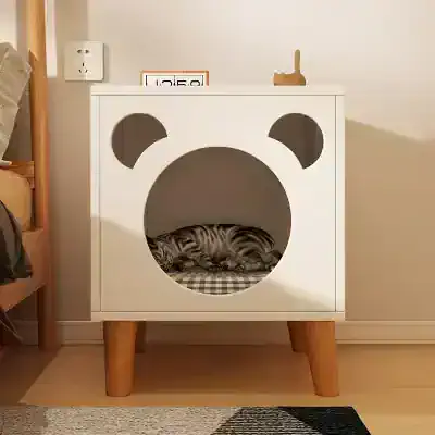 Cat sleeping inside a modern white bear-shaped pet house with wooden legs, stylish and cozy pet furniture from Monalisa Store.