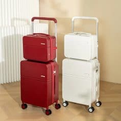 Red and white luggage sets with expandable compartments and four-wheel mobility on a light wooden floor.