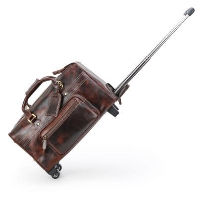 Travel luggage with leather bag and extendable handle on wheels.