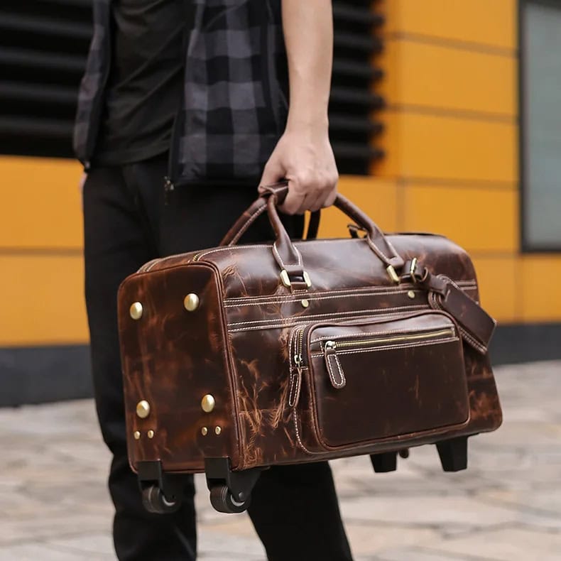 Leather travel bag with wheels, perfect for business trips and vacations, featuring multiple compartments for organized packing. Durable and stylish luggage for travelers.