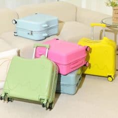Light blue and pastel-colored travel suitcases on a beige sofa, modern luggage for travel, Monalisa Store travel accessories, baggage sets with wheels, colorful travel gear for vacation and trips.