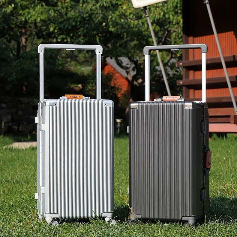 Hard shell travel suitcases on grass at Monalisa Store for premium luggage and travel accessories.