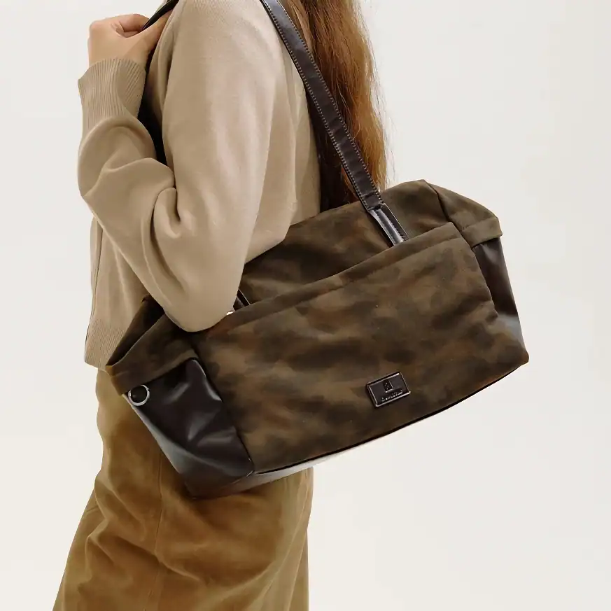 Duffel bag with leather accents for travel and daily use, featuring a spacious interior, sturdy shoulder strap, and stylish design, perfect for busy professionals and travelers.