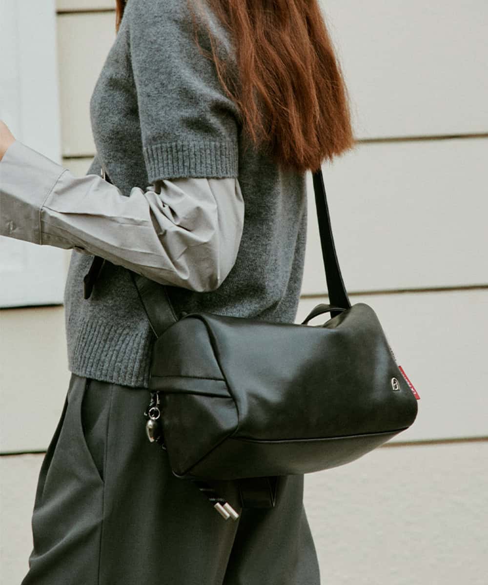 Black leather messenger bag for women, stylish and versatile accessory for daily use, work, or travel, with durable construction and secure zip closure. Perfect for fashion-forward and practical shoppers.