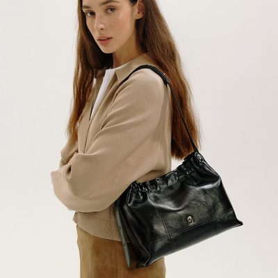 Luxurious black leather shoulder bag with a sleek design and adjustable strap, perfect for stylish women seeking casual elegance and practicality. Ideal for daily wear and versatile outfits.