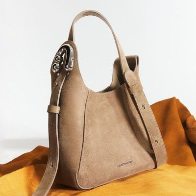 Beige luxury handbag with silver hardware and adjustable strap, elegant accessory for fashion-forward women.