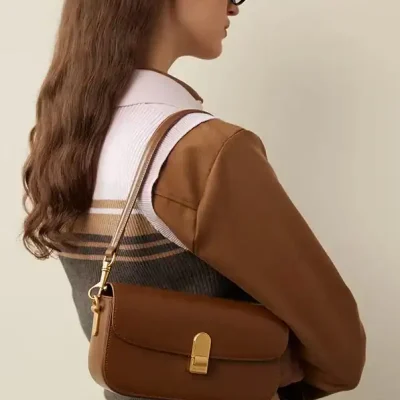 Brown leather handbag with gold hardware for women's fashion and accessories.