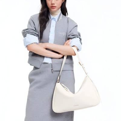 Elegant woman holding a white Monalisa store designer bag, showcasing luxury accessories and fashion. Perfect for style-conscious shoppers looking for premium bags and accessories.