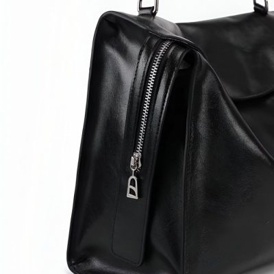 Black leather handbag with zipper detail, stylish and functional accessory perfect for women.