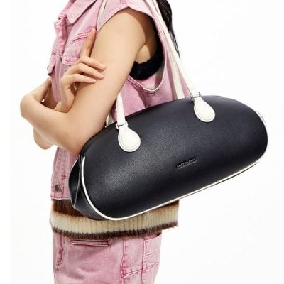 Black leather duffel bag with white accents, ideal for travel or gym use. Stylish and spacious, perfect for women seeking durable, fashionable accessories.