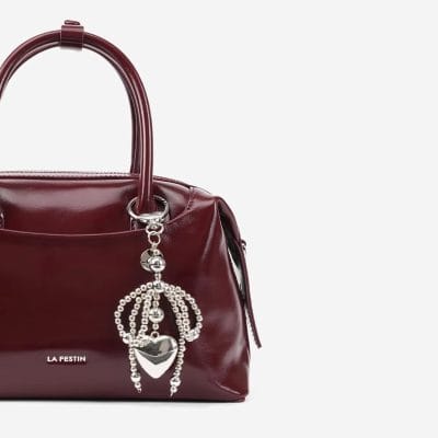Elegant maroon leather handbag with decorative silver charm, perfect for stylish women seeking high-quality accessories at Monalisa Store.
