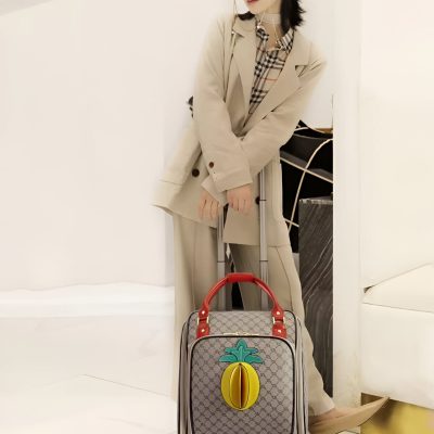 Luggage with a colorful fruit design and rolling wheels at Monalisa Store, showcasing trendy travel accessories for fashion-forward travelers.