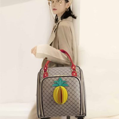 Elegant woman with designer patterned suitcase, fashionable beige trench coat, stylish cap and glasses, showcasing luxury travel accessories from Monalisa Medical Store.