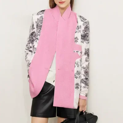 Stylish woman wearing a pink and black floral blazer, white top, black leather shorts, and tall black boots, holding a black handbag, showcasing modern fashion at Monalisa Store.