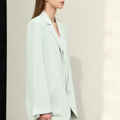 Elegant young woman in a white blazer and pants, showcasing modern fashion at Monalisa Store for optical and eyewear accessories.