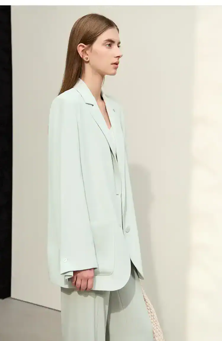 Elegant young woman in a white blazer and pants, showcasing modern fashion at Monalisa Store for optical and eyewear accessories.