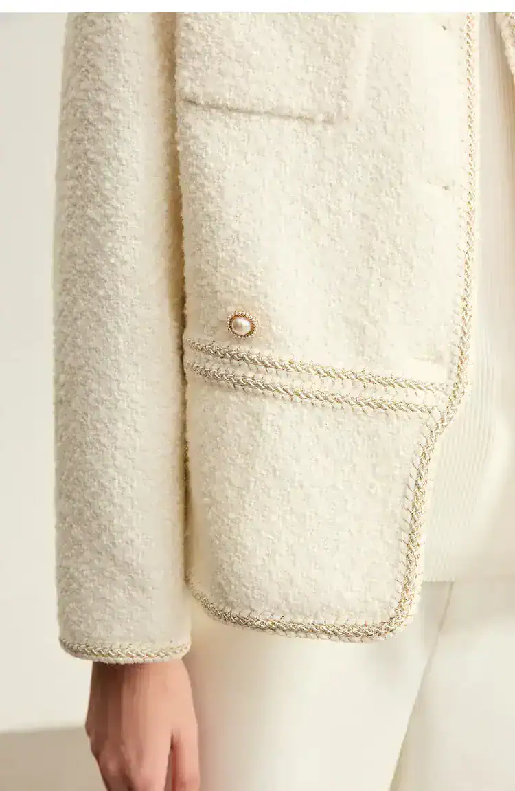 Luxurious cream-colored tweed blazer with elegant pearl button details, perfect for sophisticated fashion statements and upscale occasions.