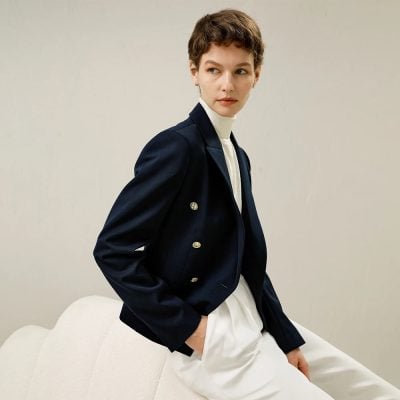 Elegant woman wearing a tailored navy blazer and white turtleneck for professional business attire, showcasing stylish and sophisticated fashion options at Monalisa Store.